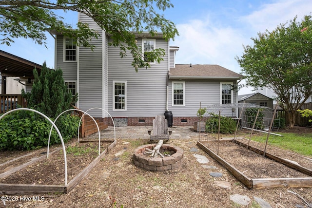 206 Lansing Ct, Jacksonville, NC 28540 - rear view of property featuring a garden, crawl space, a shingled roof, and an outdoor fire pit