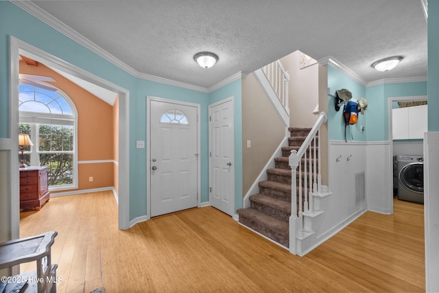 206 Lansing Ct, Jacksonville, NC 28540 - entrance foyer with washer / clothes dryer, a textured ceiling, wood finished floors, stairs, and crown molding