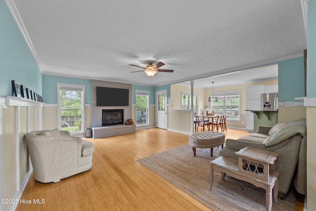 206 Lansing Ct, Jacksonville, NC 28540 - living area with ornamental molding, light wood-style floors, a ceiling fan, healthy amount of natural light, and a brick fireplace