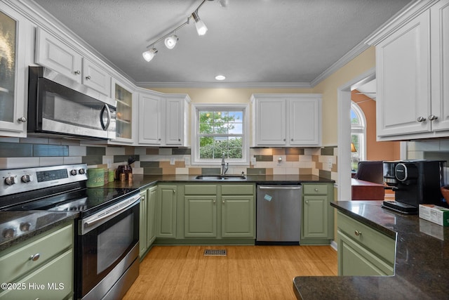 206 Lansing Ct, Jacksonville, NC 28540 - kitchen with stainless steel appliances, green cabinets, a sink, light wood-style flooring, and white cabinetry