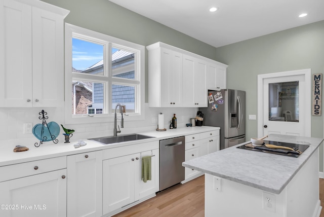 2021 Seawind Ln, Wilmington, NC 28405 - kitchen with appliances with stainless steel finishes, a sink, light wood finished floors, white cabinetry, and recessed lighting
