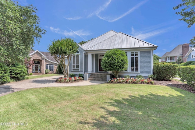 2021 Seawind Ln, Wilmington, NC 28405 - view of front facade featuring a front lawn, metal roof, and driveway