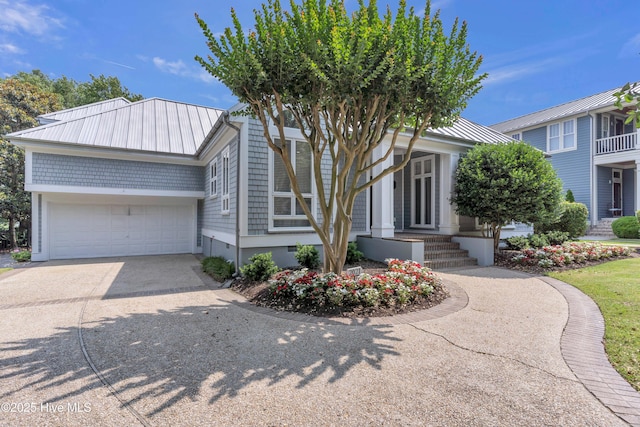2021 Seawind Ln, Wilmington, NC 28405 - view of front of property featuring a garage, concrete driveway, and metal roof