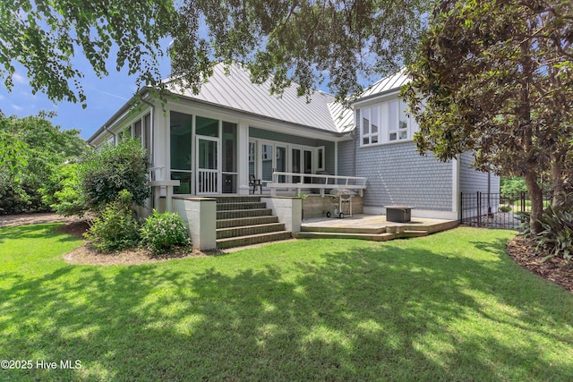 2021 Seawind Ln, Wilmington, NC 28405 - back of property featuring a sunroom, a wooden deck, a standing seam roof, a yard, and metal roof