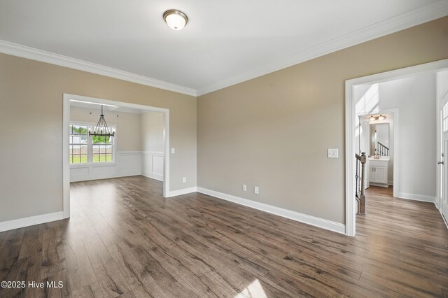 33 Chippewa Ln, Rocky Point, NC 28457 - spare room featuring a chandelier, ornamental molding, dark wood-type flooring, baseboards, and wainscoting