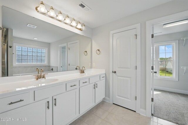 33 Chippewa Ln, Rocky Point, NC 28457 - bathroom featuring double vanity, healthy amount of natural light, tile patterned floors, and baseboards
