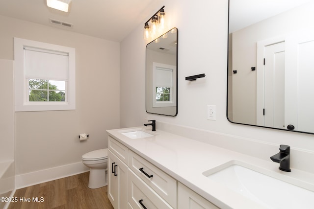 245 Winborne Ln, Edenton, NC 27932 - bathroom featuring wood finished floors, baseboards, double vanity, toilet, and a bathtub