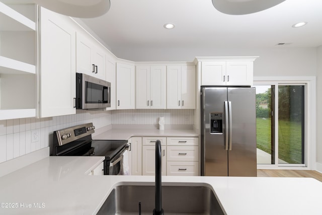 245 Winborne Ln, Edenton, NC 27932 - kitchen with stainless steel appliances, open shelves, a sink, light countertops, and white cabinetry