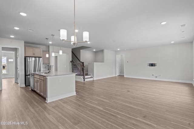 81 Eagle Claw Dr, Calabash, NC 28467 - kitchen featuring appliances with stainless steel finishes, a sink, a center island with sink, open floor plan, and light wood-style flooring