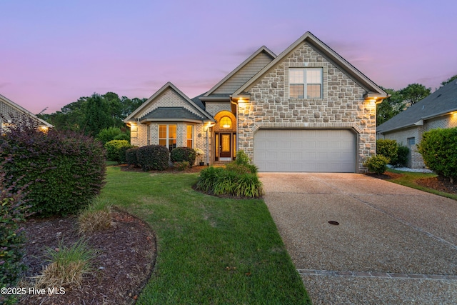 310 White Swan Ct, Wilmington, NC 28412 - view of front of house with stone siding, concrete driveway, a front lawn, and a garage