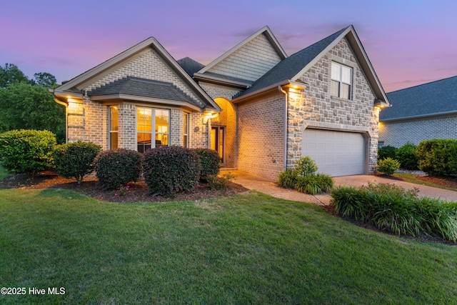 310 White Swan Ct, Wilmington, NC 28412 - view of front of house with driveway, a front lawn, an attached garage, stone siding, and brick siding