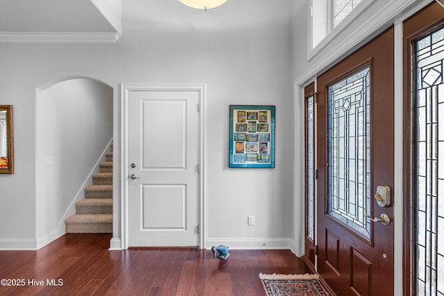 310 White Swan Ct, Wilmington, NC 28412 - foyer featuring baseboards, dark wood-style floors, stairway, crown molding, and arched walkways