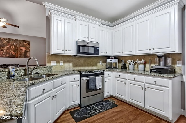 3509 Wales Pl N, Wilson, NC 27896 - kitchen with stainless steel appliances, a sink, white cabinetry, and wood finished floors