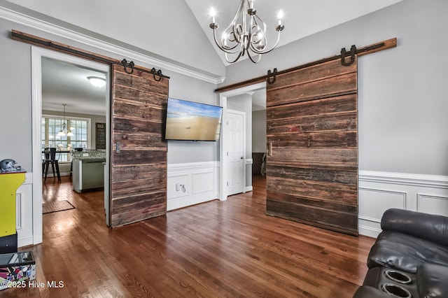 3509 Wales Pl N, Wilson, NC 27896 - living area with a barn door, a chandelier, wood finished floors, lofted ceiling, and a wainscoted wall