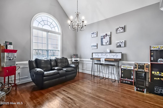 3509 Wales Pl N, Wilson, NC 27896 - living room with a chandelier, wood finished floors, a decorative wall, wainscoting, and high vaulted ceiling