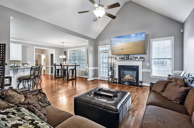 3509 Wales Pl N, Wilson, NC 27896 - living room featuring ceiling fan, high vaulted ceiling, a glass covered fireplace, wood finished floors, and baseboards