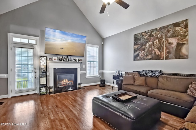 3509 Wales Pl N, Wilson, NC 27896 - living room featuring high vaulted ceiling, a glass covered fireplace, healthy amount of natural light, a ceiling fan, and wood finished floors