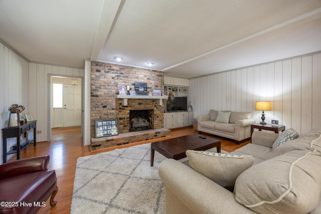 202 Forest Dr, Clinton, NC 28328 - living room featuring wood finished floors, a textured ceiling, and a fireplace
