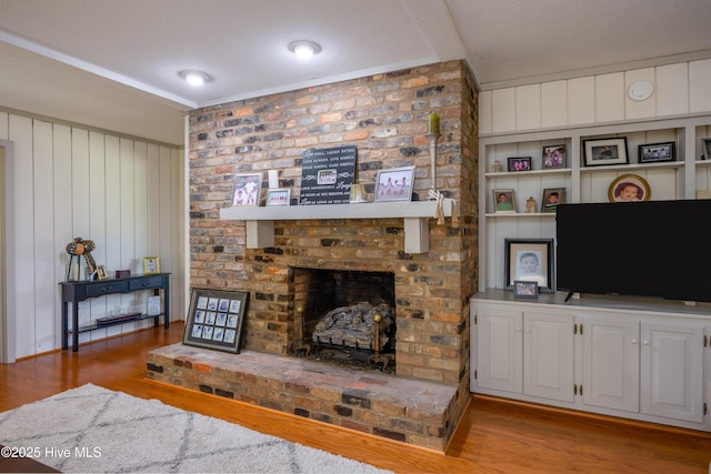202 Forest Dr, Clinton, NC 28328 - living area featuring wood finished floors, a fireplace, wood walls, and a textured ceiling