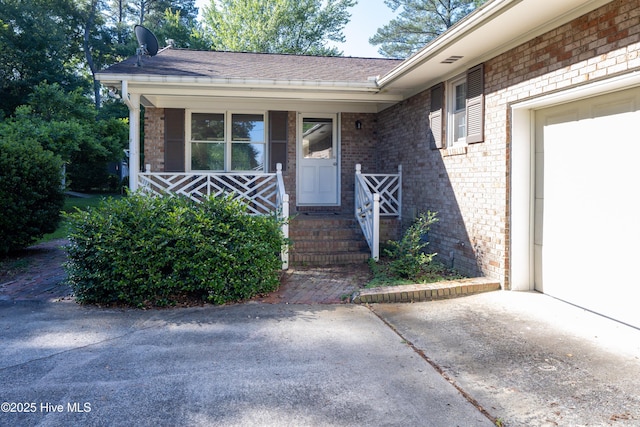 202 Forest Dr, Clinton, NC 28328 - property entrance featuring brick siding, covered porch, and a shingled roof
