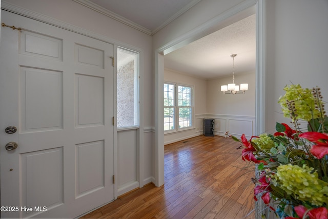 202 Forest Dr, Clinton, NC 28328 - foyer with light wood finished floors, a chandelier, ornamental molding, and wainscoting