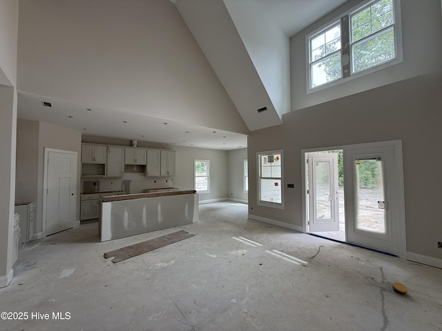 520 Harrow Dr, Carthage, NC 28327 - kitchen featuring a towering ceiling, white cabinetry, open floor plan, a kitchen island, and baseboards