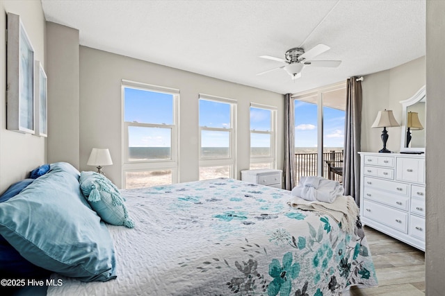2000 New River Inlet Rd Unit 1208, North Topsail Beach, NC 28460 - bedroom featuring access to exterior, wood finished floors, a textured ceiling, and ceiling fan
