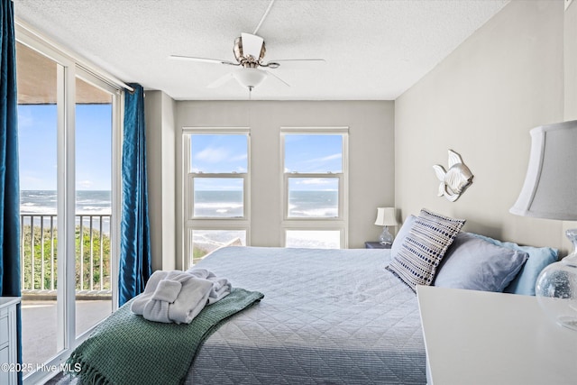 2000 New River Inlet Rd Unit 1208, North Topsail Beach, NC 28460 - bedroom featuring a textured ceiling, a water view, and ceiling fan