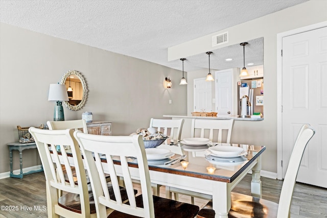 2000 New River Inlet Rd Unit 1208, North Topsail Beach, NC 28460 - dining space featuring wood finished floors, baseboards, and a textured ceiling