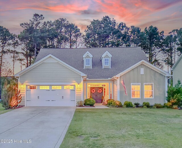 411 Canvasback Ln, Sneads Ferry, NC 28460 - view of front of home featuring board and batten siding, a yard, concrete driveway, a garage, and roof with shingles