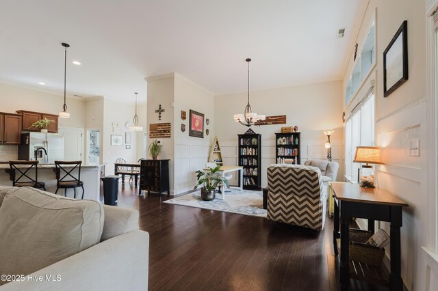 411 Canvasback Ln, Sneads Ferry, NC 28460 - living room featuring dark wood-style flooring, a chandelier, crown molding, and recessed lighting