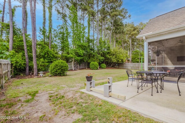 411 Canvasback Ln, Sneads Ferry, NC 28460 - view of yard featuring a sunroom, a patio area, view of scattered trees, and outdoor dining space
