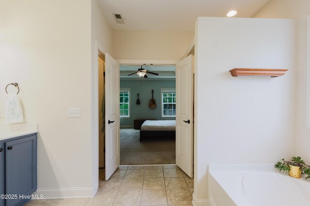 411 Canvasback Ln, Sneads Ferry, NC 28460 - ensuite bathroom featuring vanity, a bath, baseboards, and ceiling fan