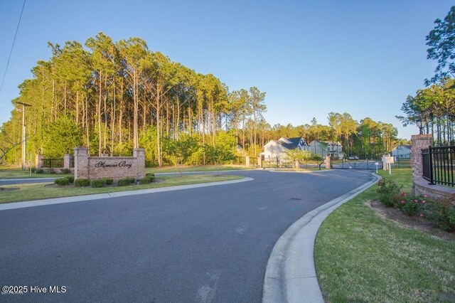 411 Canvasback Ln, Sneads Ferry, NC 28460 - view of asphalt road with curbs and a gated entry