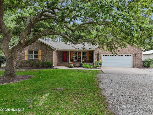 827 Village Point Rd SW, Shallotte, NC 28470 - view of front of property with covered porch, driveway, a front lawn, brick siding, and an attached garage