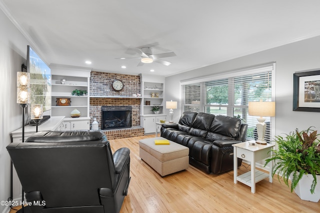 827 Village Point Rd SW, Shallotte, NC 28470 - living room featuring light wood-style floors, crown molding, a ceiling fan, a fireplace, and recessed lighting