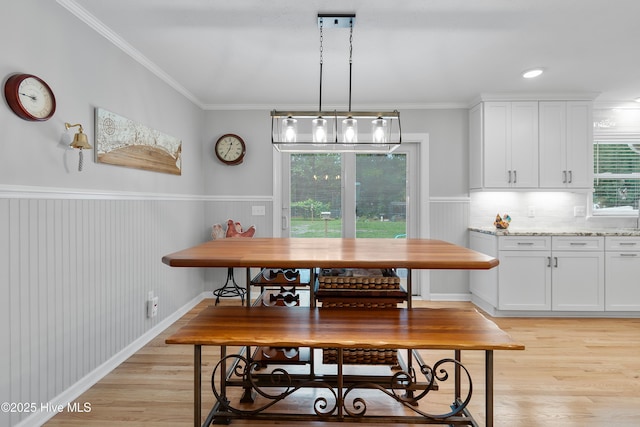 827 Village Point Rd SW, Shallotte, NC 28470 - dining area with light wood-type flooring, wainscoting, crown molding, and breakfast area
