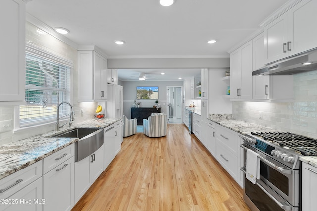827 Village Point Rd SW, Shallotte, NC 28470 - kitchen with range with two ovens, a sink, under cabinet range hood, white cabinetry, and crown molding