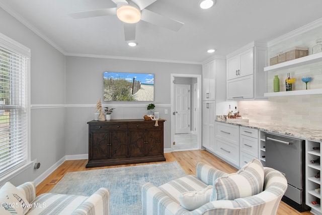 827 Village Point Rd SW, Shallotte, NC 28470 - living room with healthy amount of natural light, wainscoting, light wood-style floors, ceiling fan, and crown molding