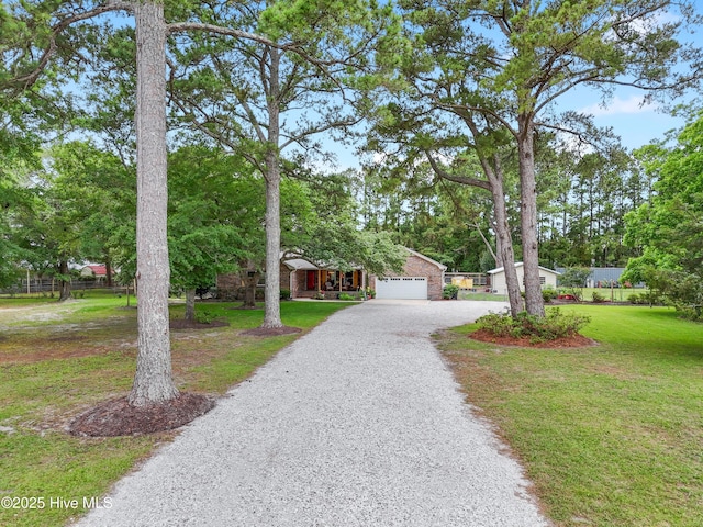 827 Village Point Rd SW, Shallotte, NC 28470 - obstructed view of property with driveway, an attached garage, and brick siding