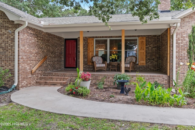 827 Village Point Rd SW, Shallotte, NC 28470 - view of exterior entry with covered porch, brick siding, and a chimney