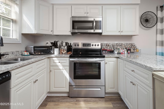 229 Trappers Trl, New Bern, NC 28560 - kitchen with appliances with stainless steel finishes, white cabinetry, wood finished floors, and light stone countertops