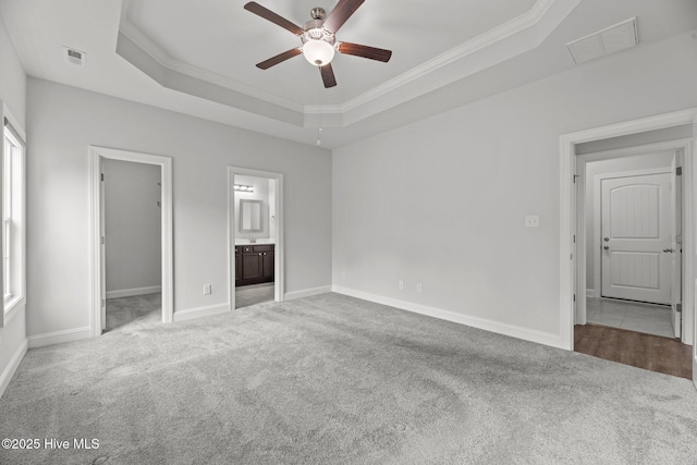 1005 Flounder Run, New Bern, NC 28562 - unfurnished bedroom featuring carpet floors, ornamental molding, a tray ceiling, baseboards, and a spacious closet