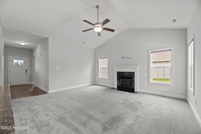 1005 Flounder Run, New Bern, NC 28562 - unfurnished living room featuring carpet flooring, ceiling fan, a fireplace with flush hearth, vaulted ceiling, and baseboards