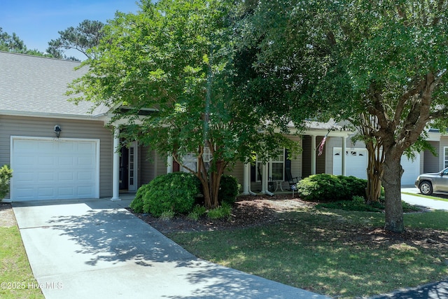 4256 Anderson Dr SE, Southport, NC 28461 - view of property hidden behind natural elements with driveway, an attached garage, and a shingled roof