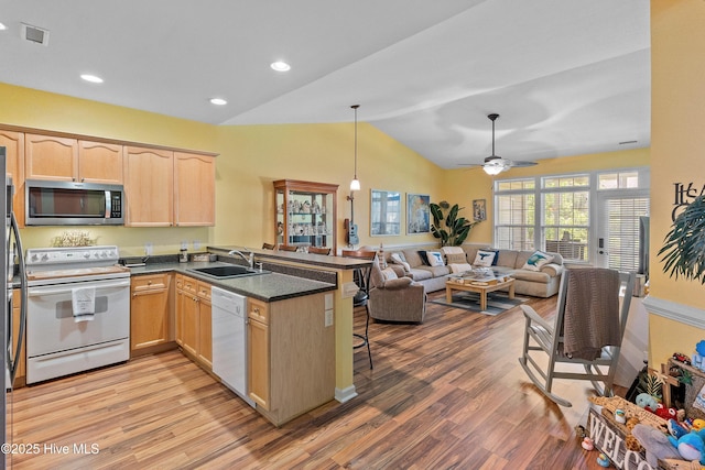 4256 Anderson Dr SE, Southport, NC 28461 - kitchen featuring white appliances, light brown cabinetry, a sink, a peninsula, and light wood-type flooring