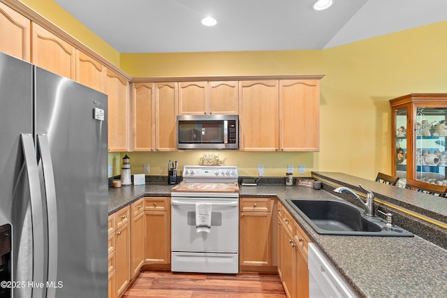 4256 Anderson Dr SE, Southport, NC 28461 - kitchen featuring appliances with stainless steel finishes, a sink, light brown cabinetry, light wood-style flooring, and recessed lighting