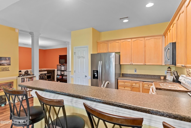4256 Anderson Dr SE, Southport, NC 28461 - kitchen with stainless steel refrigerator with ice dispenser, light brown cabinetry, white electric stove, ornate columns, and dark countertops