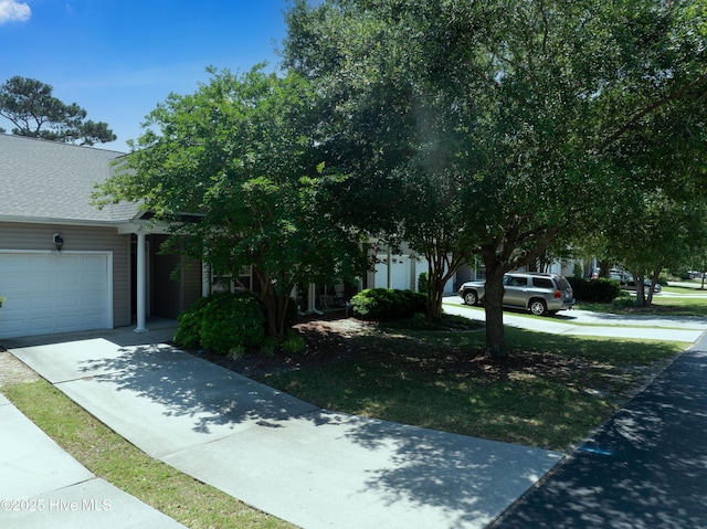 4256 Anderson Dr SE, Southport, NC 28461 - obstructed view of property with driveway, an attached garage, and a shingled roof