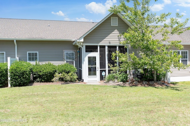 4256 Anderson Dr SE, Southport, NC 28461 - rear view of property featuring a shingled roof, a lawn, and a sunroom